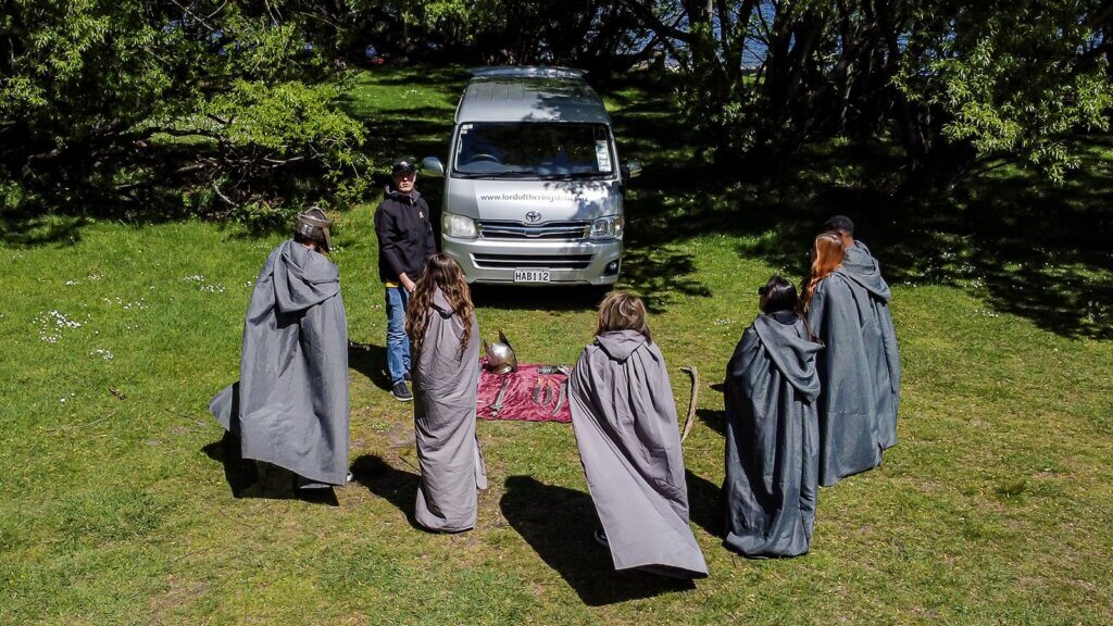 Group in front of tour van with guide and selection of props for role playing